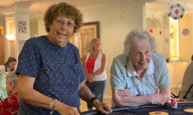 Two residents enjoying a game in an activity room