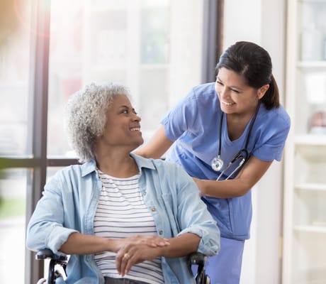 Caregiver assisting a resident in a bright interior