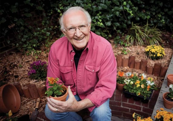 Resident smiling in a garden with flowers