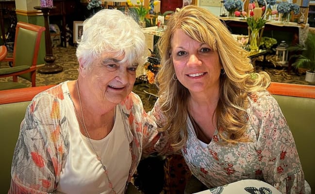 Two women smiling together in a common area