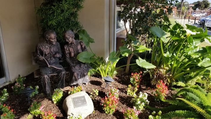 Outdoor garden statue of a couple among plants