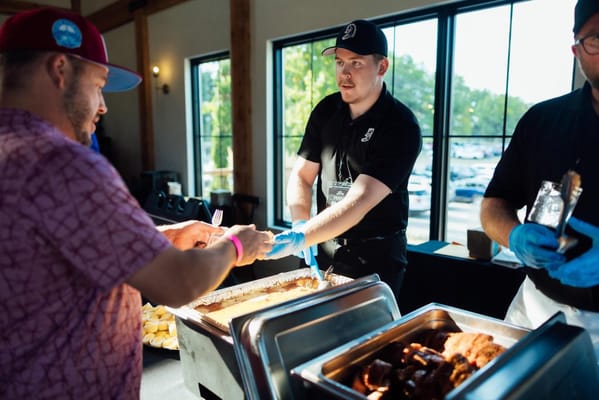 Staff serving food at an event with residents