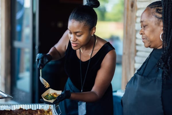 Staff serving food to residents at an outdoor event