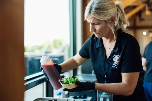 Staff member preparing food in an indoor setting