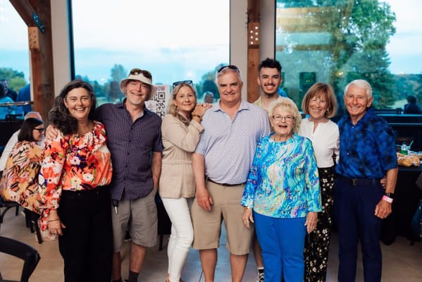 Group of residents and staff smiling together at a celebration