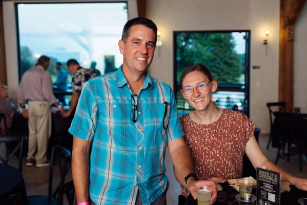 Two smiling people enjoying a gathering in a common area