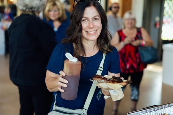 A woman holding food at a gathering event in a common area