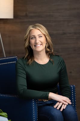A woman smiling while seated in a chair