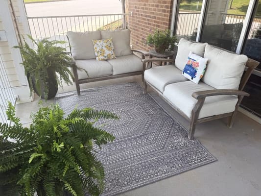 Cozy outdoor seating area with plants and cushions