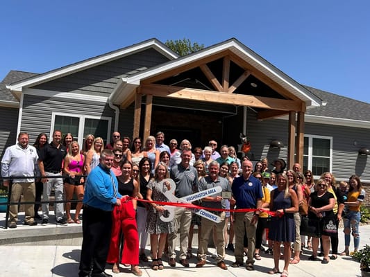 Ribbon-cutting ceremony with large group of people outside