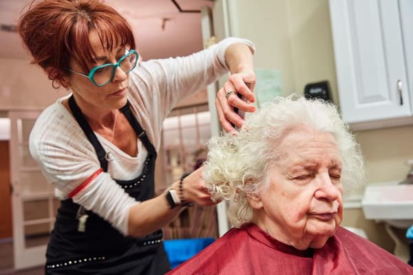 A stylist giving a perm to an elderly resident