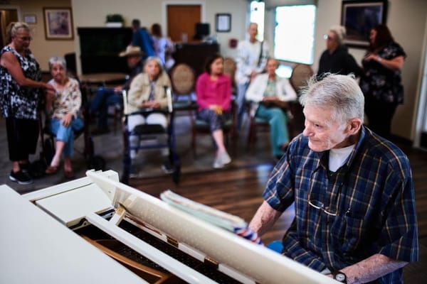 Residents enjoying a piano performance in the common area