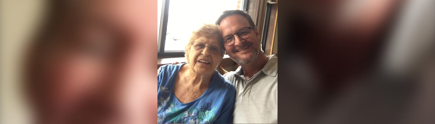 A senior resident and staff member smiling together