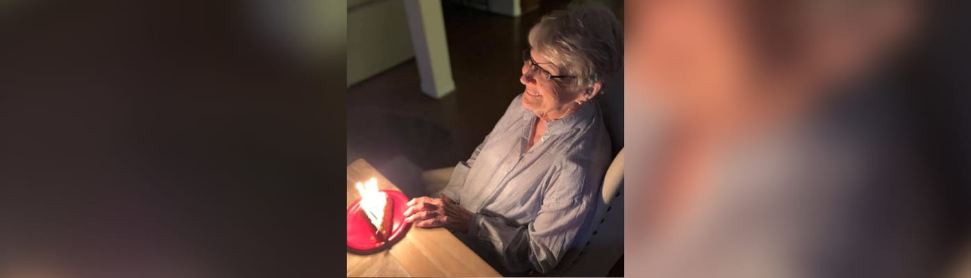 A senior woman celebrating with a cake