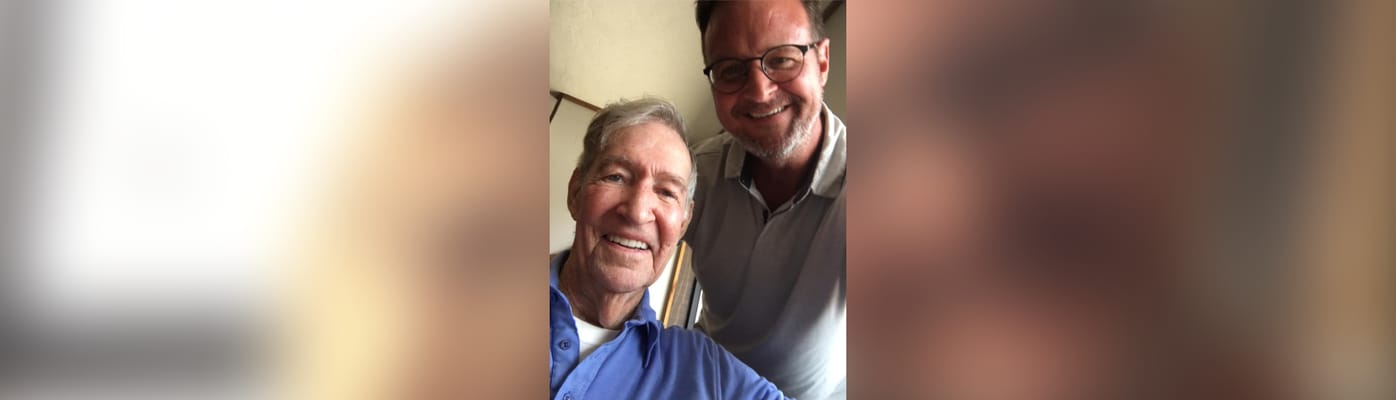 Two smiling men posing together indoors