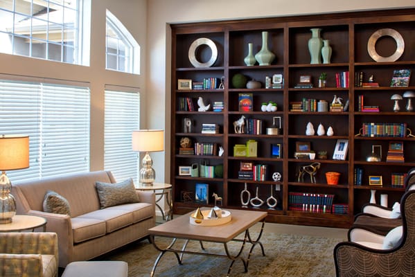Comfortable lounge with a couch, lamps, and a bookshelf.