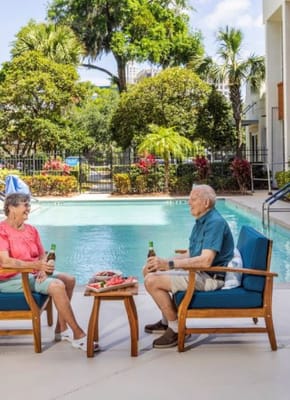 Two residents enjoying drinks by the pool