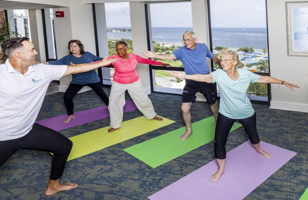Residents participating in a yoga class in a bright room