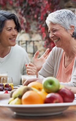 Residents enjoying food and conversation at a table