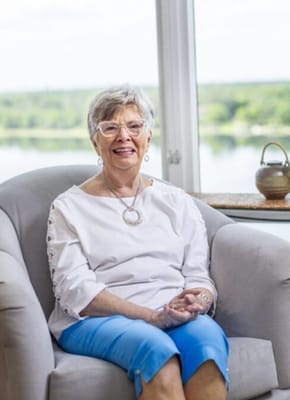 Smiling resident sitting in a bright common area
