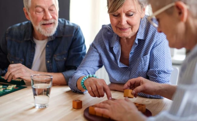 Residents engaging in a game at a table