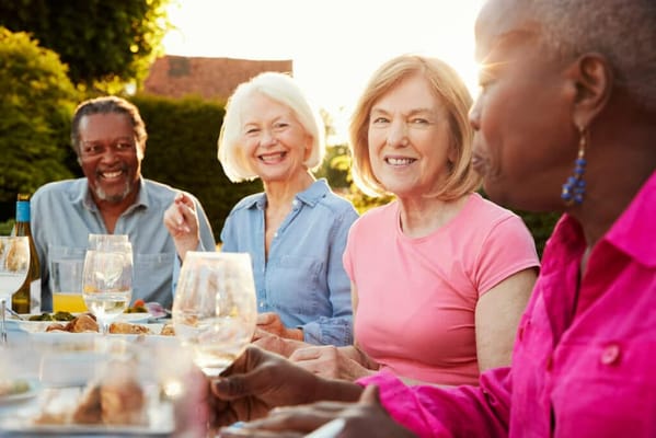 Residents enjoying a meal outdoors at a table