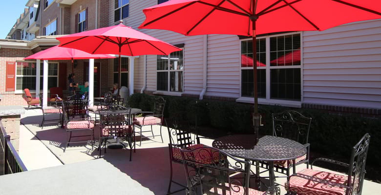 Outdoor patio area with red umbrellas and seating
