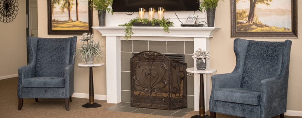 Cozy common area with blue chairs and fireplace