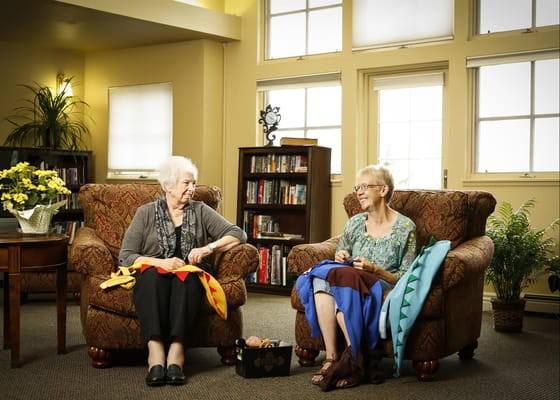 Two residents enjoying conversation in a cozy lounge area