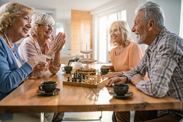 Seniors enjoying a game of chess and snacks together