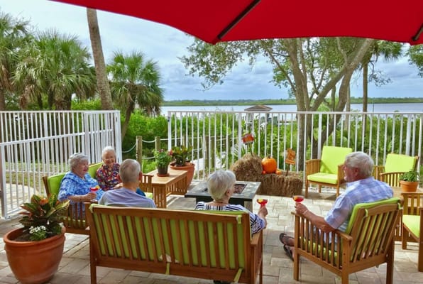 Residents enjoying drinks on a patio by the water