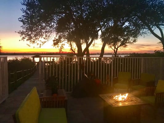 Outdoor seating area at sunset by the water