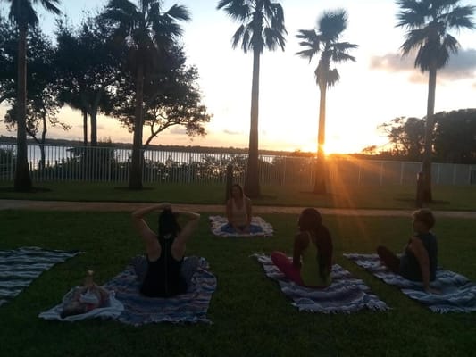 Residents participating in outdoor yoga during sunset