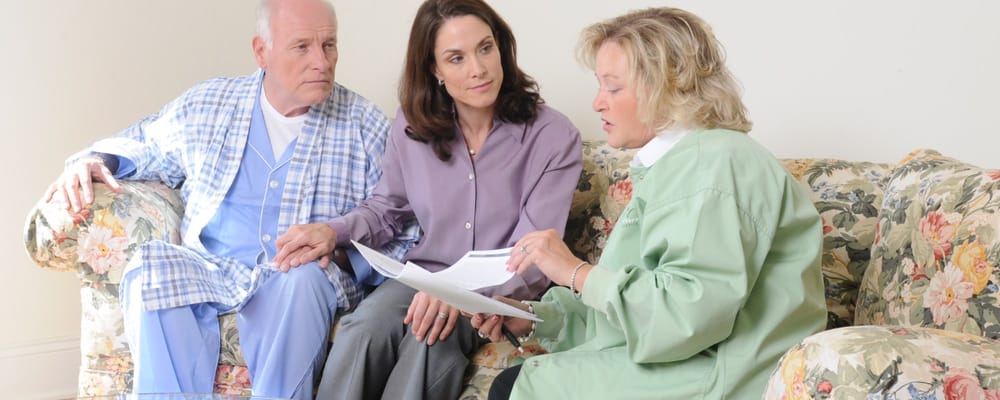 Staff discussing care plans with residents in a common area