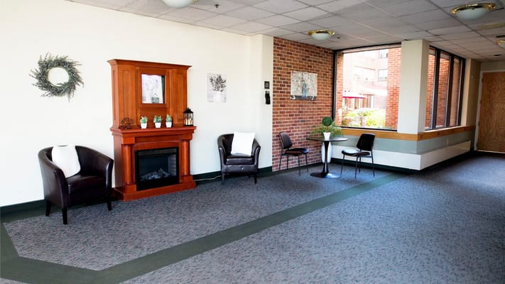 Bright common area with seating and a fireplace