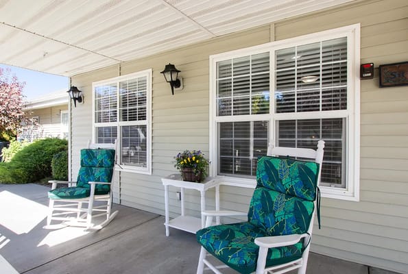 Outdoor seating area with rocking chairs and potted plants