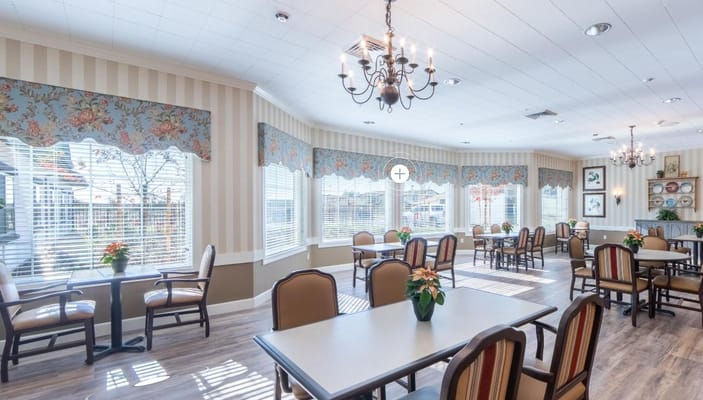 Brightly lit dining area with tables and chairs.