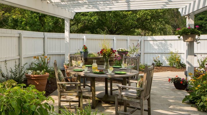 Outdoor patio dining area with lush greenery