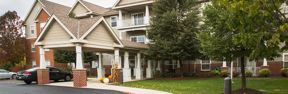 Exterior view of a senior living facility with trees and landscaping