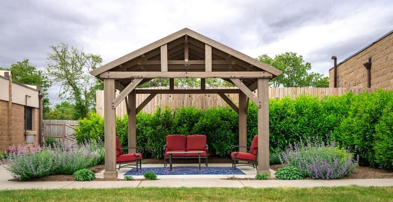 Outdoor seating area with a pergola and shrubs