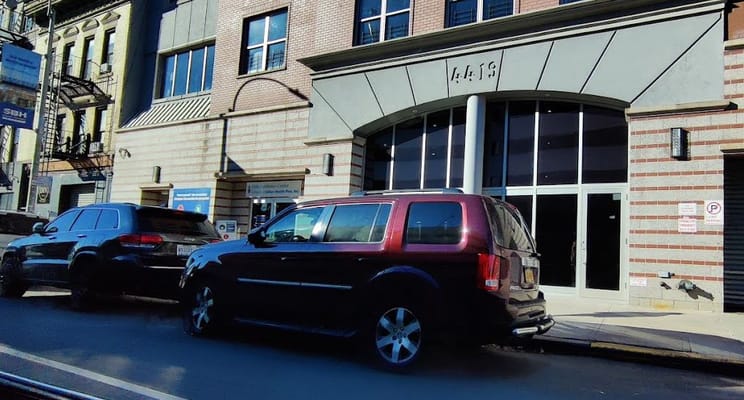 Exterior view of a facility with vehicles parked in front
