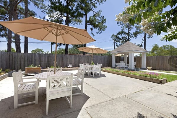 Outdoor patio area with shaded seating and flowers