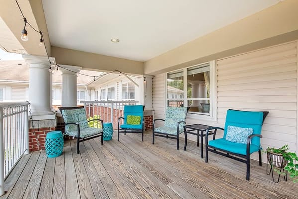 Outdoor seating area with turquoise chairs and tables on a wooden patio