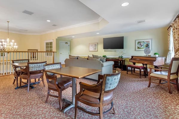 Common area with seating and piano at Brookdale Woodward Estates