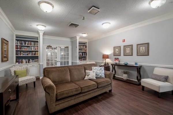 Cozy living room with a sofa, bookcase, and lamps.