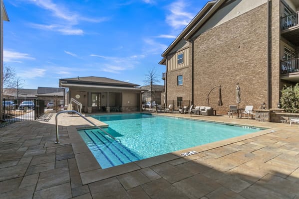 Swimming pool area with seating and lounge chairs