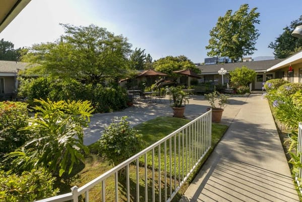 Relaxing courtyard with greenery and seating at Claremont Care Center.
