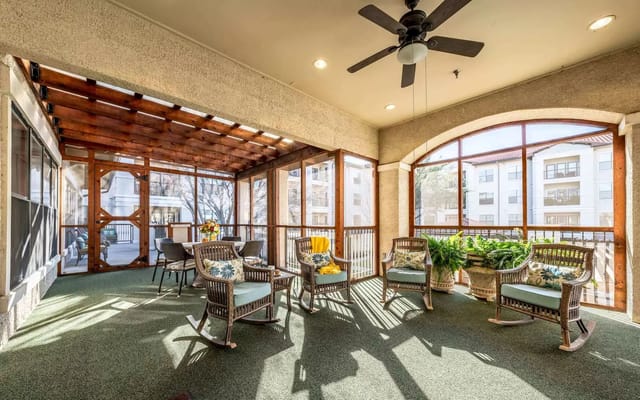 Sunlit common area with rocking chairs and potted plants