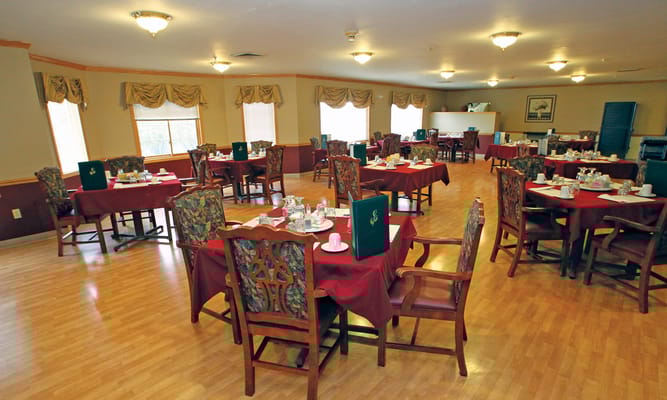 Spacious dining area with red tablecloths and floral chairs