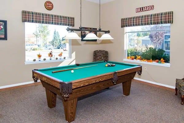 A well-lit billiards table in a common area